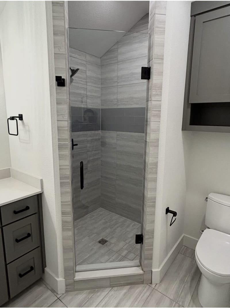 Gray tile frameless corner shower with matte black hardware