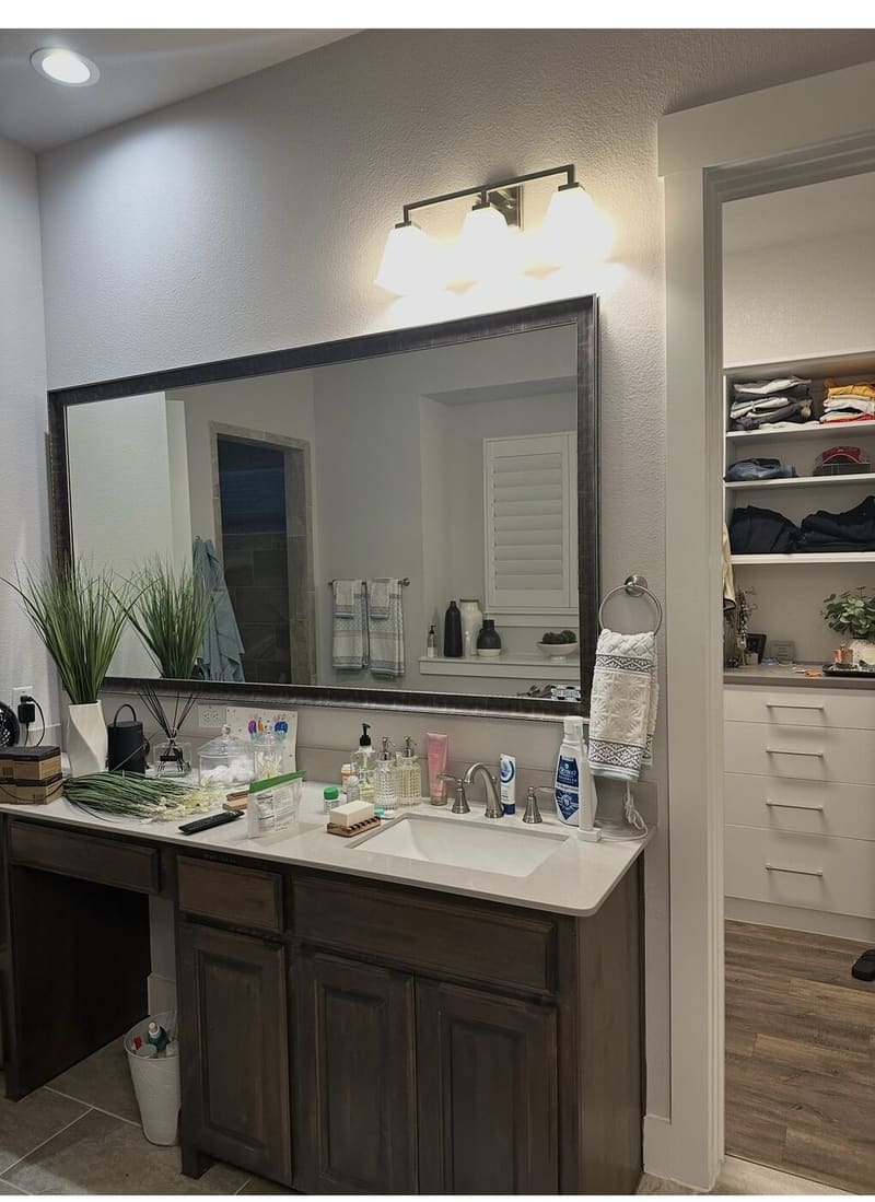 Bathroom vanity remodel with framed mirror and walk-in closet