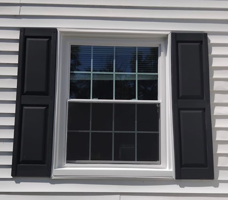 Newly installed double-hung window with black shutters by Red Moon Expert